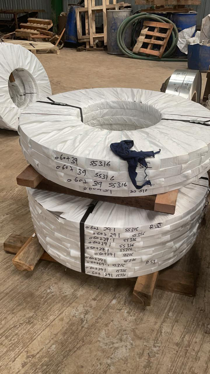 Wrapped SS 316 strip coils marked with width and thickness, strapped on wooden pallets