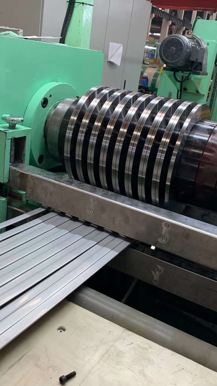 Rotary circular slitting knives set to width on the arbor of the slitter head